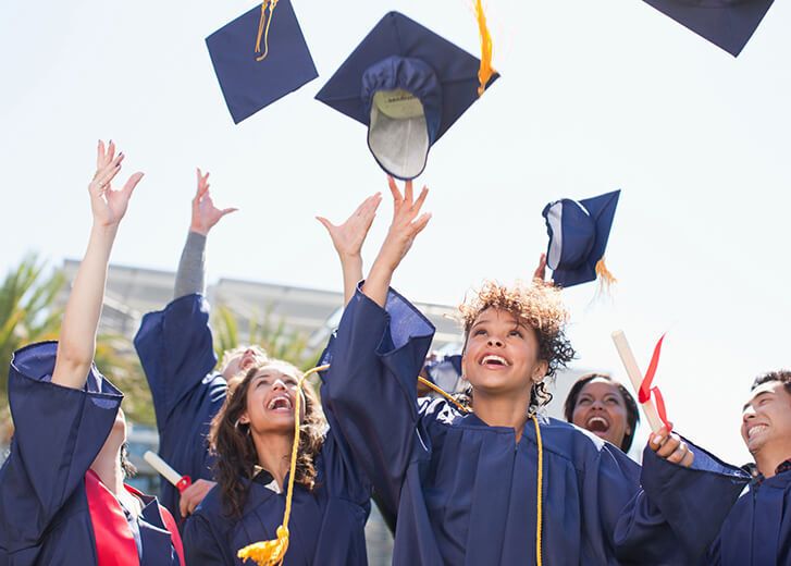 Graduates tossing caps into the air